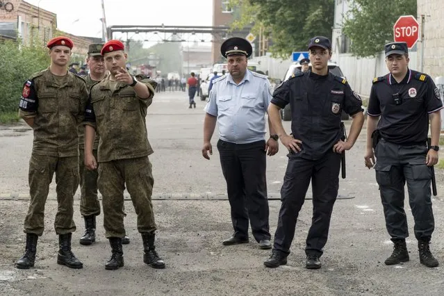 Military police and police officers guard an entrance of the side of the Zagorsk Optical and Mechanical Plant after the blast in the city of Sergiev Posad, Moscow Region, about 65 km (41miles) north-east of Moscow, Russia on Wednesday, August 9, 2023. An explosion Wednesday, on the grounds of a factory north of Moscow that makes optical equipment for Russia's security forces wounded dozens people, six of them severely, officials said. (Photo by AP Photo/Stringer)