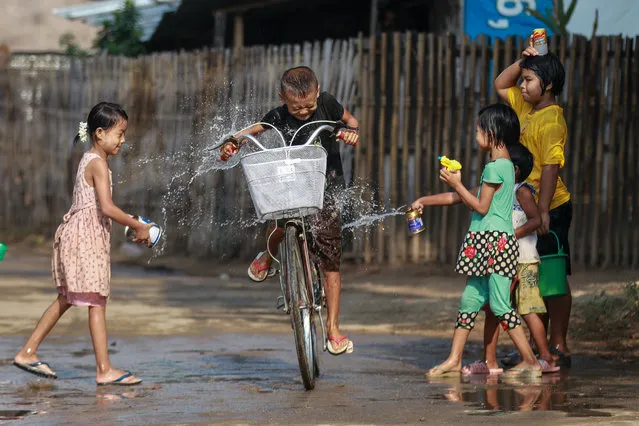 Children douse a child on a bicycle with water to mark the Thingyan Water Festival at a village in Naypyitaw, Myanmar, 14 April 2021. Myanmar anti-coup activists have called for people to boycott official Thingyan festivities organized by the military junta. The Thingyan Water Festival, the Burmese traditional New Year, is usually celebrated with family reunions and water-throwing festivities. According to the Assistance Association for Political Prisoners (AAPP), at least 700 people have been killed by Myanmar armed forces since the military seized power on 01 February 2021. Protests continue despite the intensifying crackdown on demonstrators. (Photo by EPA/EFE/Stringer)