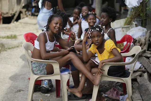 Youths pose for a photo, while doing their homework in an area once home to chop houses, where gangs dismembered enemies, but is now a “humanitarian space” in Buenaventura, Colombia, Wednesday, August 16, 2023. (Photo by Fernando Vergara/AP Photo)