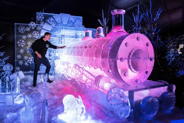 Ice sculptor Mark Hackney puts the finishing touches to a steam train carved from ice, during a photocall to promote the “Ice Village”, in central Manchester, northern England on November 9, 2018. The Ice Village Manchester, which is open until January 5, 2019, features an ice cavern, ice sculptures and frozen ice bar all carved using 250 tonnes of solid ice. (Photo by Oli Scarff/AFP Photo)