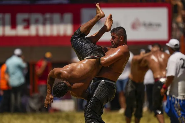 Wrestlers compete during the 661st annual Historic Kirkpinar Oil Wrestling championship, in Edirne, northwestern Turkey, Sunday, July 3, 2022. The festival is part of UNESCO's List of Intangible Cultural Heritages. (Photo by Francisco Seco/AP Photo)