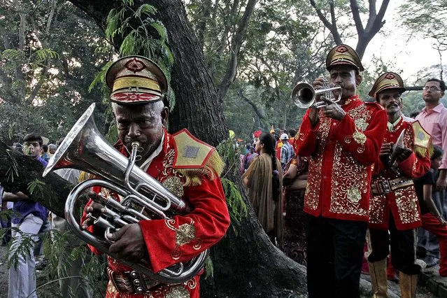 Members of a brass band perform during a procession to mark the Chhath Puja festival in Kolkata, India, on November 8, 2013. Chhath prayers thank the Sun God for sustaining life on earth. (Photo by Bikas Das/Associated Press)