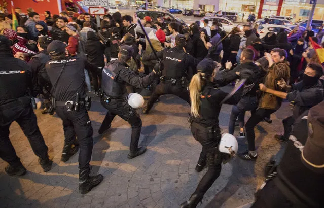 In this Wednesday, November 14, 2018 photo, Spanish police officers clash with demonstrators at the entrance of a hotel where the newcomer to Spanish politics, the far-right Vox party is holding a rally in Murcia, Spain.  Vox is reaching out to the neglected, working-class suburbs and rural areas with high unemployment, with polls predicting the Eurosceptic, anti-feminist and staunchly patriotic party on track to enter the country’s parliament in elections due before 2020. (Photo by Emilio Morenatti/AP Photo)