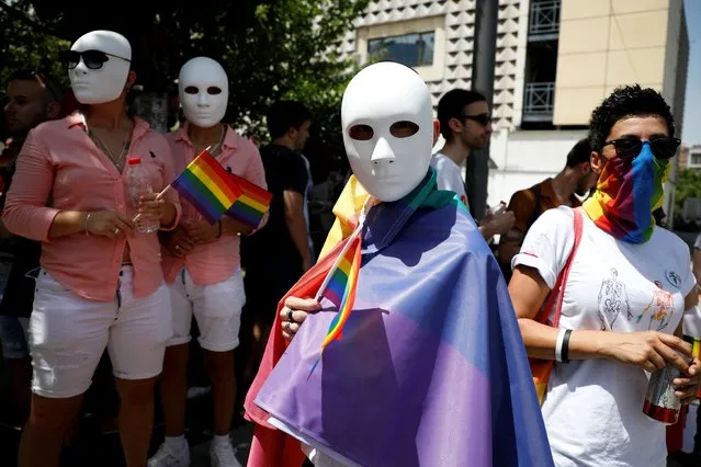 Member and supporters of LGBT community wear masks and hold rainbow flags as they gather during the annual gay pride parade in Pristina, Kosovo, July 1, 2021. (Photo by Florion Goga/Reuters)