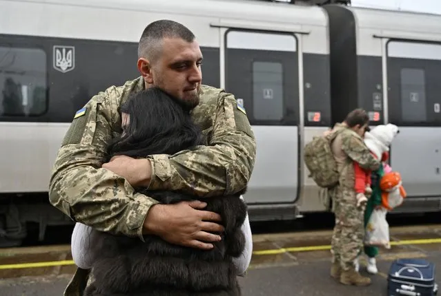 Ukrainian servicemen Dmytro, 29-years-old, embraces his wife before she boards a train heading to Kyiv, at a railway station in Kramatorsk, Donetsk region, on October 8, 2023, amid the Russian invasion of Ukraine. (Photo by Genya Savilov/AFP Photo)