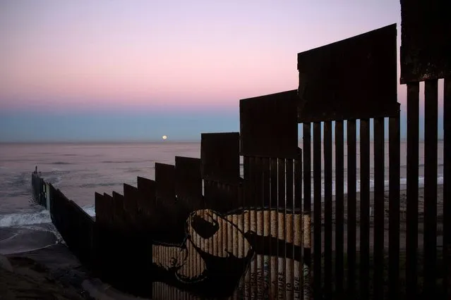 A “supermoon” sets behind the U.S. - Mexico border fence during its closest orbit to the Earth since 1948 on November 14, 2016 in Tijuana, Mexico. (Photo by Guillermo Arias/AFP Photo)