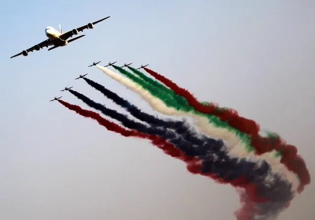 Al Fursan, the aerobatics demonstration team of the UAE Air Force perform with an Emirates Airbus 380 plane during the Dubai Airshow in Dubai, United Arab Emirates, Monday November 18, 2013. (Photo by Kamran Jebreili/AP Photo)