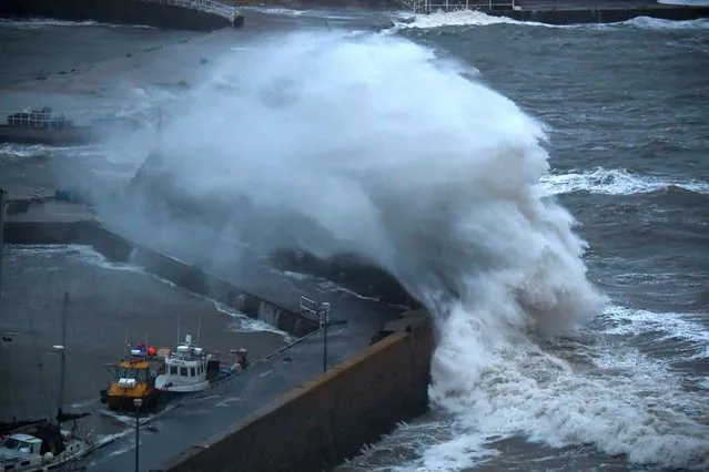 Waves crash over Stonehaven harbour on the east coast of Scotland on October 19, 2023, as wind and rain from Storm Babet cause travel chaos. (Photo by Andy Buchanan/AFP Photo)