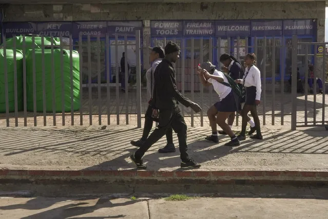 Three high school girls make their way through the city centre on their way to school in Dundee, South Africa, Friday, October 27, 2023. Thousands of children in South Africa's poorest and most remote rural communities still face a miles-long walk to school, nearly 30 years after the country ushered in democratic change. (Photo by Sebabatso Mosamo/AP Photo)