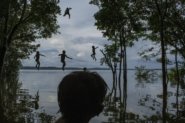 In this image released by World Press Photo titled “Amazon's Munduruku Tribe” by photographer Mauricio Lima for The New York Times which won second prize in the Daily Life singles category shows indigenous Munduruku children playing in the Tapajos river in the tribal area of Sawre Muybu, Itaituba, Brazil, February 10, 2015. (Photo by Mauricio Lima/The New York Times, World Press Photo via AP Photo)