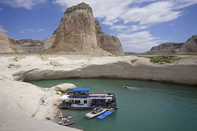 A houseboat rests in a cove at Lake Powell Friday, July 30, 2021, near Page, Ariz. This summer, the water levels hit a historic low amid a climate change-fueled megadrought engulfing the U.S. West. (Photo by Rick Bowmer/AP Photo)