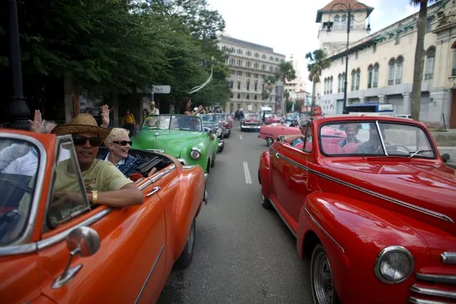Tourists enjoy a ride in vintage cars in old Havana in this January 17, 2016 picture. (Photo by Alexandre Meneghini/Reuters)