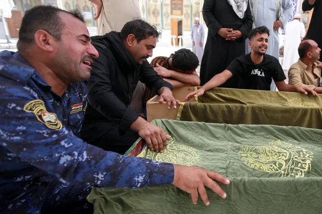 Mourners react next to the coffins of victims, who were killed in a fire that broke out at al-Hussain coronavirus hospital in Nassiriya, during a funeral in Najaf, Iraq, July 13, 2021. (Photo by Alaa Al-Marjani/Reuters)