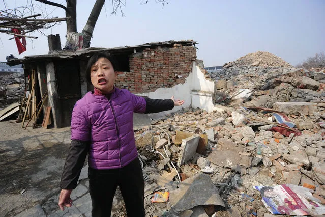 Cao Mingyun, daughter of 75-year-old Cao Wenxia, the owner of a nail house, talks to journalist in front of their house in Hefei, Anhui province, China, January 29, 2010. Cao's family refuse to move due to unsatisfied compensation for their house, the last house in the area, about to be demolished to make way for a new commercial project. (Photo by Reuters/Stringer)