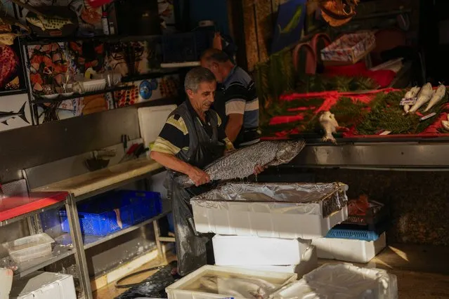 A fishmonger puts a fish inside a box in a street market at Eminonu commercial district in Istanbul, Turkey, Wednesday, September 6, 2023. (Photo by Francisco Seco/AP Photo)