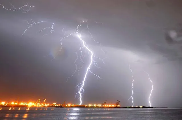Lightning streaks over the port of Montevideo during a thunderstorm early on January 2, 2014. (Photo by Mariana Suarez/AFP Photo)