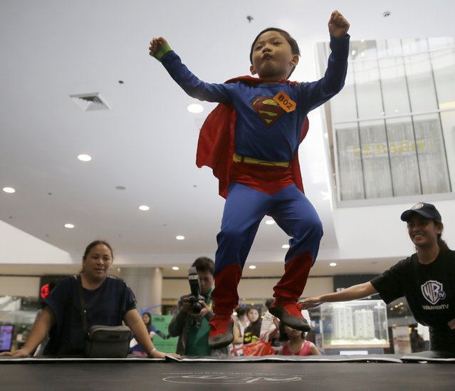 A boy, dressed as Superman, jumps on the trampoline as Filipino fans of DC comics super heroes gather at the country's largest shopping mall during an attempt to establish a world record for the most number wearing their costumes Saturday, April 18, 2015 at suburban Quezon city, northeast of Manila, Philippines. (Photo by Bullit Marquez/AP Photo)