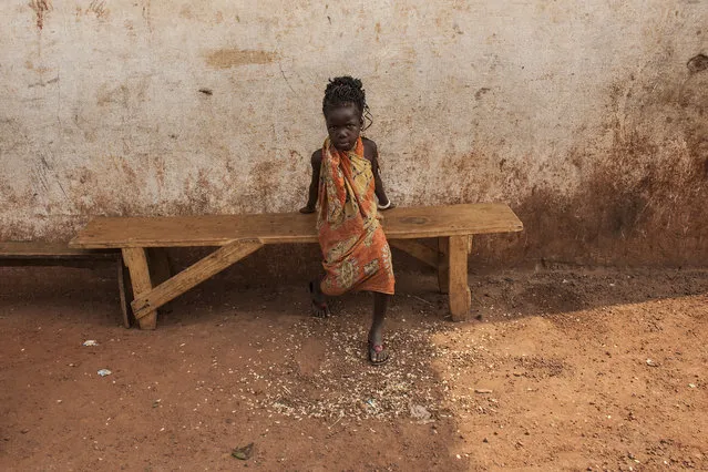 A young girl sits on a bench in M'Poko Internally Displaced Persons camp in Bangui, Central African Republic on Saturday, February 13, 2016. (Photo by Jane Hahn/The Washington Post)