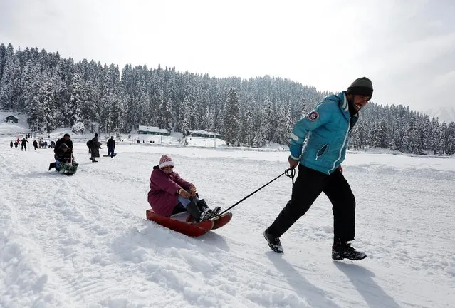 A Kashmiri man pulls a sledge carrying a tourist on a sunny day in Gulmarg, west of Srinagar, January 20, 2017. (Photo by Danish Ismail/Reuters)