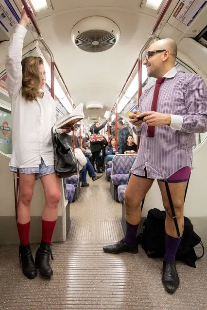 Participants in the 13th annual International “No Pants Subway Ride” travel on a London underground train in London, on January 12, 2014. (Photo by Leon Neal/AFP Photo)