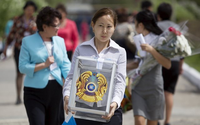 A member of a local election committee carries a ballot box during a snap presidential election in the village of Besagash, Kazakhstan, April 26, 2015. Kazakh President Nursultan Nazarbayev was set to renew his 26-year grip on power on Sunday, offering the multi-ethnic Central Asian state economic and social stability in return for what rights groups call systematic suppression of opposition. (Photo by Shamil Zhumatov/Reuters)
