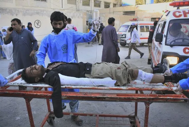 Paramedics transport a police officer who was injured in a deadly bomb blast, following his initial treatment at a hospital, in Quetta, Pakistan, Monday, October 18, 2021. A roadside bomb exploded near a police bus parked outside the Baluchistan University in Quetta, the capital of Baluchistan province in southwest Pakistan, killing and wounding people, a provincial home minister said. (Photo by Arshad Butt/AP Photo)