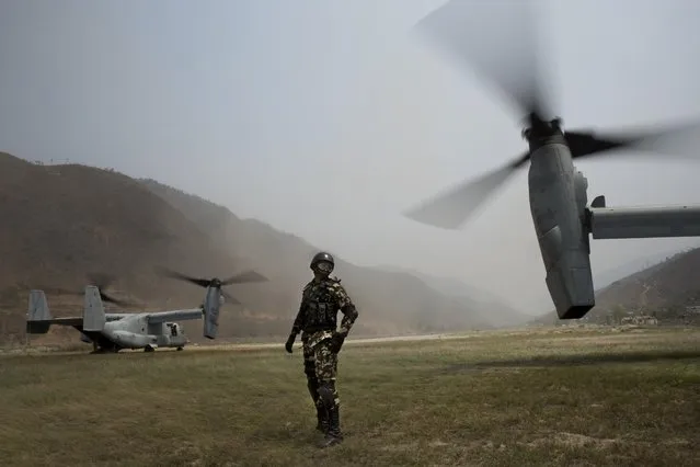 A Nepalese soldier stands between two U.S. Ospreys which are used to assist the deployment of Nepalese soldiers in the quake affected mountainous areas in Manthali, Nepal, Thursday, May 7, 2015. (Photo by Bernat Amangue/AP Photo)