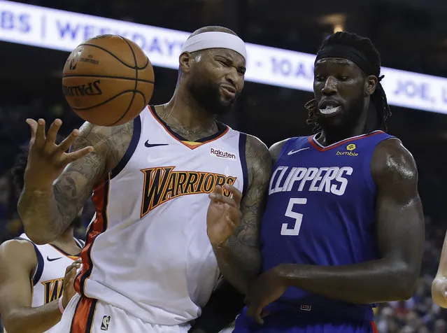 Golden State Warriors' DeMarcus Cousins, left, reacts to a foul called against him beside Los Angeles Clippers' Montrezl Harrell (5) in the first half of an NBA basketball game Sunday, April 7, 2019, in Oakland, Calif. (Photo by Ben Margot/AP Photo)