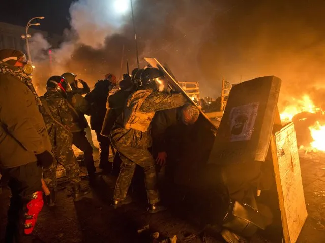 Anti-government protesters clash with riot police in Kiev's Independence Square, the epicenter of the country's current unrest. (Photo by Efrem Lukatsky/AP Photo)