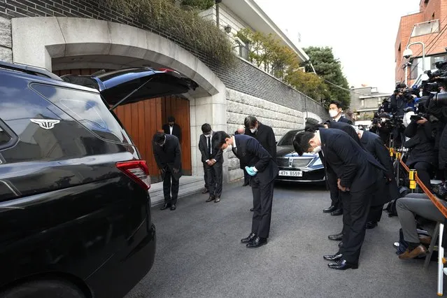Officials bow as a funeral car carrying former South Korean President Chun Doo-hwan's body leaves his house for a funeral hall in Seoul, South Korea, Tuesday, November 23, 2021. Former South Korean military strongman Chun, who crushed pro-democracy demonstrations in 1980, died on Tuesday. He was 90. (Photo by Ahn Young-joon/AP Photo)