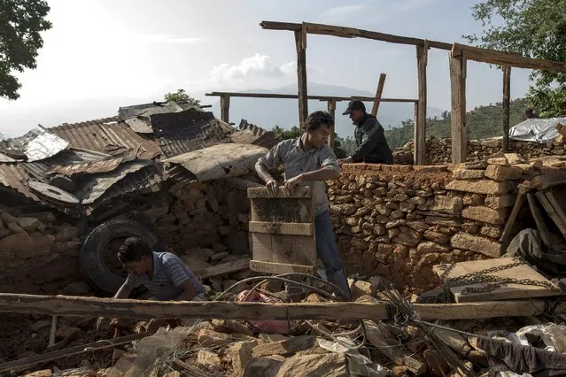 Local residents clear rubble from the ruins of their home after the April 25 earthquake in Sindhupalchowk, Nepal, May 14, 2015. (Photo by Athit Perawongmetha/Reuters)