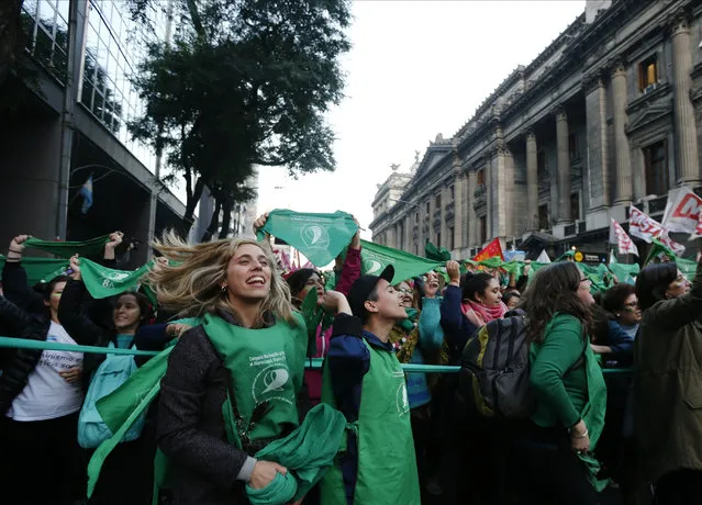Pro-choice activists shout slogans during a rally outside Congress to pressure lawmakers to legalize abortion in Buenos Aires, Argentina, Tuesday, May 28, 2019. Lawmakers said they would introduce a bill to legalize abortion for pregnancies up to 14 weeks. (Photo by Marcos Brindicci/AP Photo)