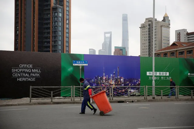 A cleaner pulls a trash container in Shanghai, China, February 21, 2017. (Photo by Aly Song/Reuters)