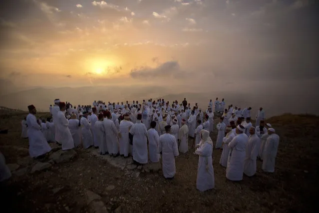 Members of the ancient Samaritan community pray during the holiday of Shavuot on Mount Gerizim near the West Bank town of Nablus, Sunday, June 9, 2019. Samaritans descended from the ancient Israelite tribes of Menashe and Efraim but broke away from mainstream Judaism 2,800 years ago. Today, the remaining 700 Samaritans live in the Palestinian city of Nablus in the West Bank and the Israeli seaside town of Holon, south of Tel Aviv. (Photo by Majdi Mohammed/AP Photo)
