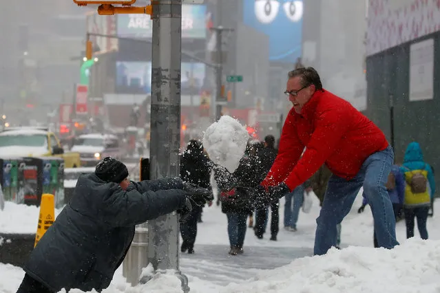 A man and child take part in a snowball fight in Times Square during a snowstorm, New York, U.S., March 14, 2017. (Photo by Carlo Allegri/Reuters)