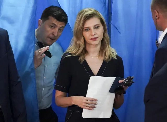 Ukrainian President Volodymyr Zelenskiy, ,left, and his wife Olena Zelenska leave a booth at a polling station during a parliamentary election in Kiev, Ukraine, Sunday, July 21, 2019. Ukrainians are voting in an early parliamentary election in which the new party of President Volodymyr Zelenskiy is set to take the largest share of votes. (Photo by Evgeniy Maloletka/AP Photo)