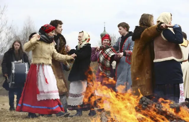 People, wearing traditional costumes, dance as they celebrate the national rite Gukanne Vyasny (Spring welcoming) at the Belarussian State Museum of Folk Architecture and Rural Lifestyle near the village of Aziarco in Minsk region, Belarus, March 18, 2017. (Photo by Vasily Fedosenko/Reuters)
