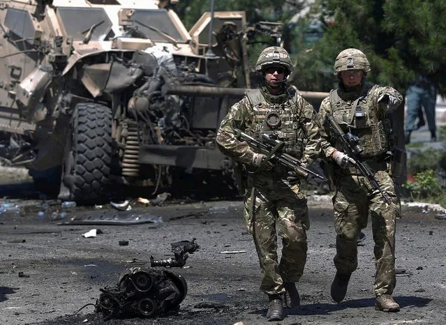 NATO soldiers walk at the site of a suicide bomb attack in Kabul, Afghanistan June 30, 2015. (Photo by Ahmad Masood/Reuters)