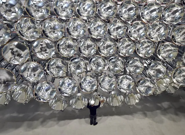 Employee, Volkmar Dohmen, stands in front of Xenon arc lamps that form a large artifical sun at the German Aerospace Center (DLR) in Juelich, Germany, 21 March 2017. A large artifical sun called Synlight can emit up to 10,000 times the intensity of the sun's light. (Photo by Caroline Seidel/Picture-alliance/DPA/AP Images)