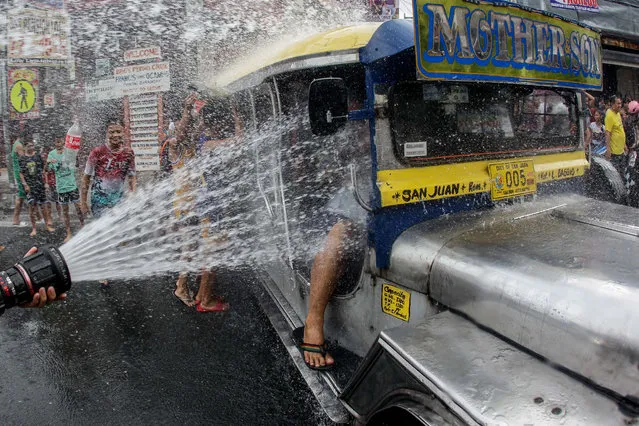 People riding in a jeepney are doused with water during the “Wattah-Wattah Festival” celebrated on Saint John the Baptist' Feast Day in San Juan City, east of Manila, Philippines, 24 June 2019. Local residents and visitors celebrate by dousing each other with water and with good cheer in honor of the city's patron saint John the Baptist, who is popularly known in Catholicism as the one who baptized Jesus Christ. (Photo by Mark R. Cristino/EPA/EFE)