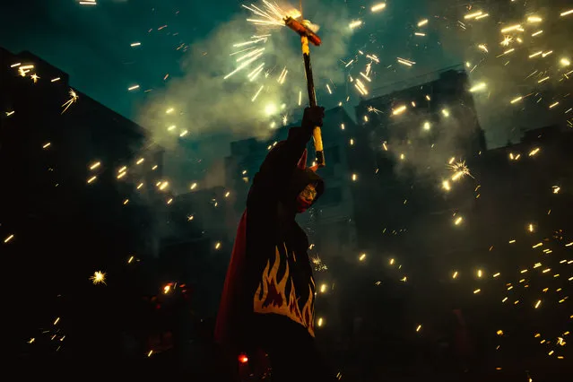 Fire runners of the “Diables Vell de la Gracia” group dance to traditional drums under fireworks celebrating their 40th anniversary, but without the traditional involvement of the public due to CORONA-19 measures in Barcelona, Spain on June 5, 2021. (Photo by Matthias Oesterle/Zuma Wire/Rex Features/Shutterstock)