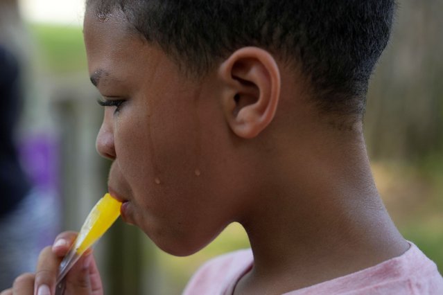 Zariah Fields eats a popsicle, Thursday, June 20, 2024, at YMCA Camp Kern in Oregonia, Ohio. As the first heat wave of the season ripples across the U.S., summer camps are working to keep their children cool while still letting the kids enjoy being outside with nature. (Photo by Joshua A. Bickel/AP Photo)