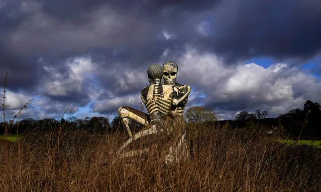 “The Nuba Survival” is a five-metre-tall statue of two skeletons locked in an embrace in Checkendon, Oxfordshire on Friday, February 4, 2022. The statue was created by local artist John Buckley – best known for his sculpture of a shark sticking out of a roof in Headington – in 2001 after he visited the Nuba peoples in Sudan. (Photo by Steve Parsons/PA Images via Getty Images)