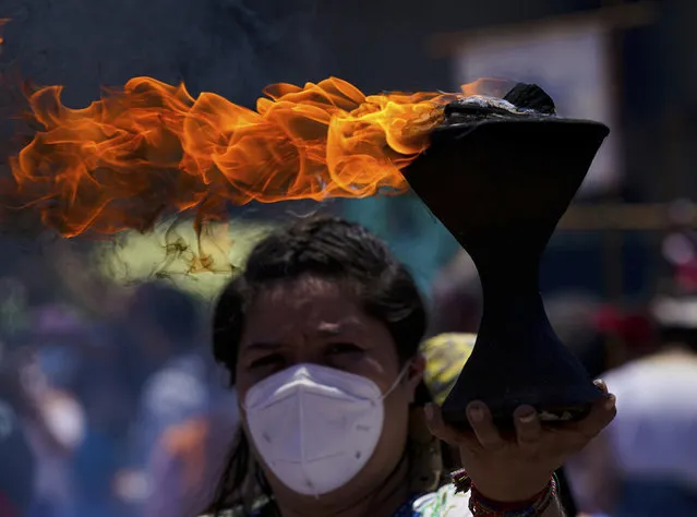 A dancer hold a censer during a performance commemorating the 700 year anniversary of the founding of the Aztec city of Tenochtitlan, known today as Mexico City, at Zocalo square in Mexico City, Monday, July 26, 2021, amid the new coronavirus pandemic. (Photo by Fernando Llano/AP Photo)