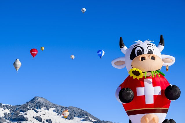 Hot-air balloons fly during the 44th International Hot Air Balloon Festival in Chateau-d'Oex, Switzerland on January 20, 2024. (Photo by Jean-Christophe Bott/EPA/EFE)