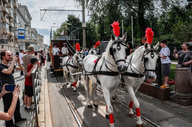 People look at the horse-drawn tram “Conca” (1872) during the street exhibition “Retro Tram Parade” as part of marking the 125th anniversary of the city tramway service in Moscow, Russia on 13 July 2024. (Photo by Yuri Kochetkov/EPA/EFE)