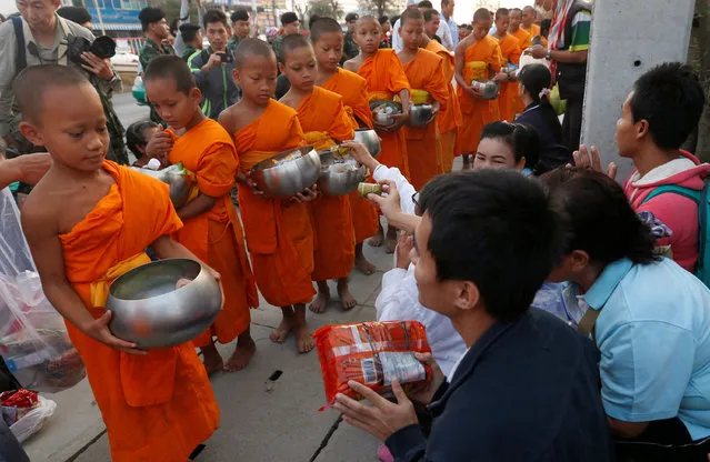 Buddhist novices receive food from people outside Dhammakaya temple in Pathum Thani province, Thailand February 22, 2017. (Photo by Chaiwat Subprasom/Reuters)