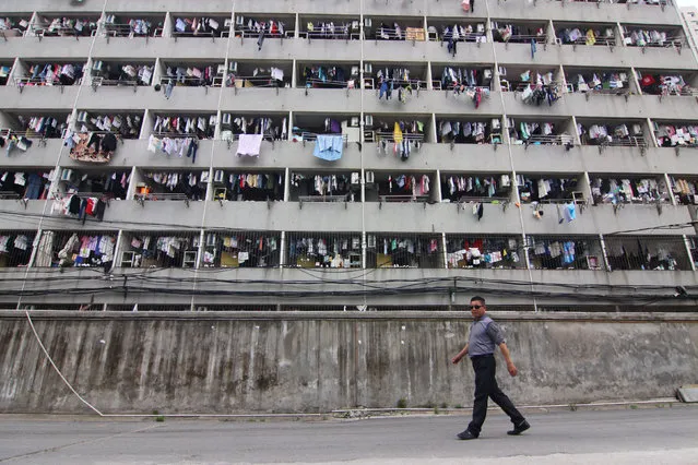 A man walks past student dormitories where clothes are hang at balconies in Wuhan, Hubei Province, China, May 17, 2016. (Photo by Reuters/Stringer)