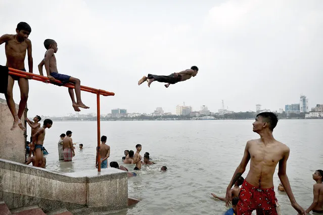A boy dives into the Ganges River during a hot day in Kolkata, India, 20 April 2022. The summer, or pre-monsoon season, occurs from March to July in eastern India, with the highest daytime temperatures ranging from 35 to 45 degrees Celsius. (Photo by Piyal Adhikary/EPA/EFE)