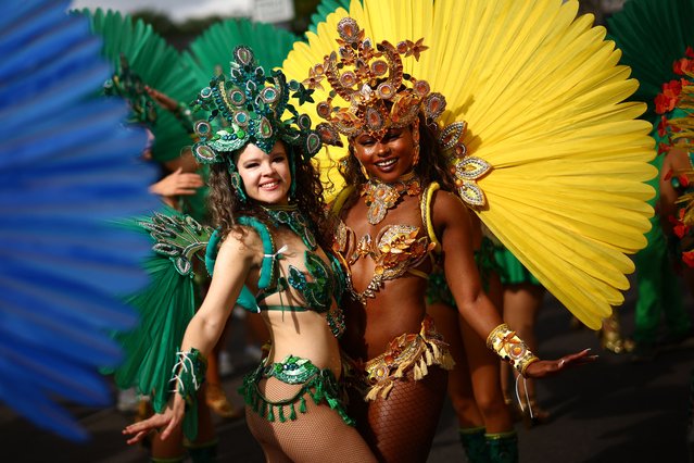 Performers in costume pose for a photo as they prepare to take part in the main parade of the Notting Hill Carnival in west London on August 26, 2024. (Photo by Henry Nicholls/AFP Photo)